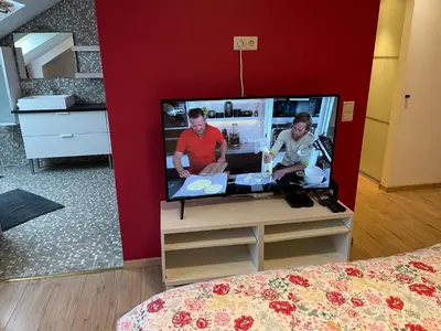 a tv in a room with two people on it at B&B groot-bijgaarden center in Groot-Bijgaarden