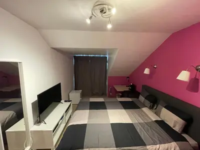 a bedroom with a bed and a pink wall at B&B groot-bijgaarden center in Groot-Bijgaarden
