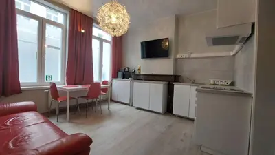 a kitchen with a table and a couch in a room at Albert Studio's in Mechelen