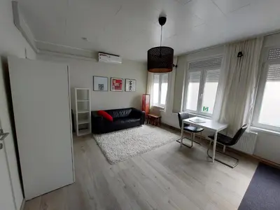 a living room with a black couch and a table at Albert Studio's in Mechelen
