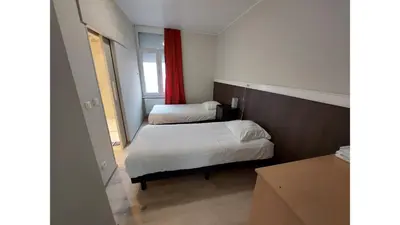 a bedroom with two beds and a red curtain at Albert Studio's in Mechelen