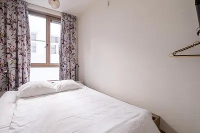 a white bed in a room with a window at De Moriaan Antwerp Historic Center in Antwerp