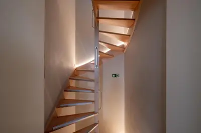 a staircase in a house with wooden shelves at De Moriaan Antwerp Historic Center in Antwerp