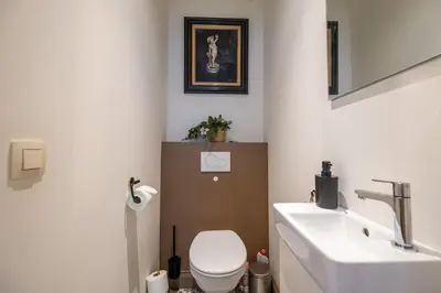 a bathroom with a white toilet and a sink at De Moriaan Antwerp Historic Center in Antwerp