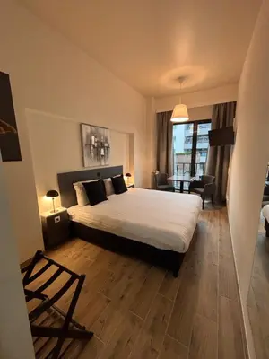 a bedroom with a bed and a living room at Hotel Aviation in Brussels