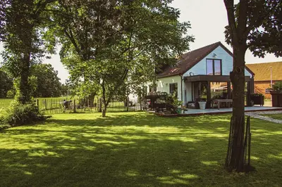 a house with a fence and a yard with trees at D&A nest in Retie