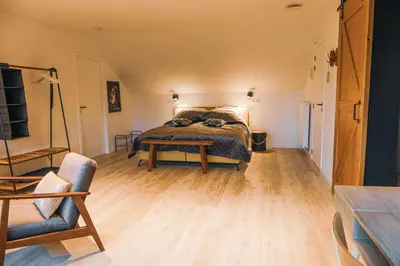 a bedroom with a bed and a wooden floor at D&A nest in Retie