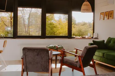 a living room with a table and chairs and windows at D&A nest in Retie