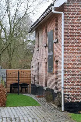 a brick building with a sign on the side of it at Maison des Étoiles in Aalst