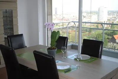 a dining room table with chairs and a large window at Apartment View of Antwerp in Antwerp