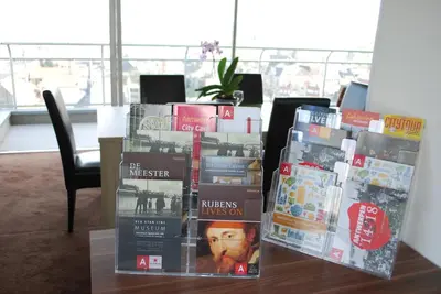 a pile of books sitting on top of a table at Apartment View of Antwerp in Antwerp