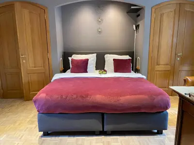 a bedroom with a large bed with a red blanket at B&B Monroe in Averbode