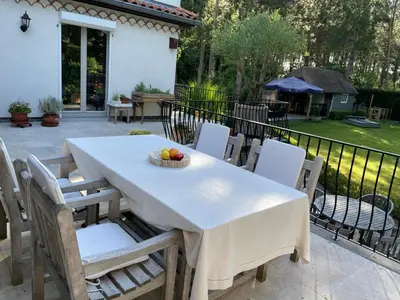a white table and chairs with a bowl of fruit on it at B&B Monroe in Averbode