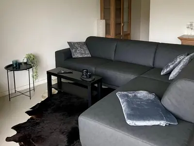 a living room with a couch and a table at Duplex appartement in rustige woonwijk in Mortsel