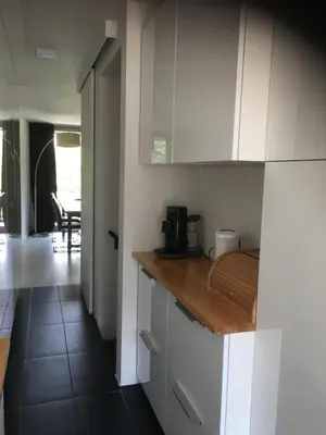a kitchen with white cabinets and a wooden counter top at Duplex appartement in rustige woonwijk in Mortsel