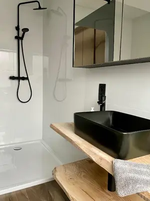 a bathroom with a black sink and a shower at Duplex appartement in rustige woonwijk in Mortsel
