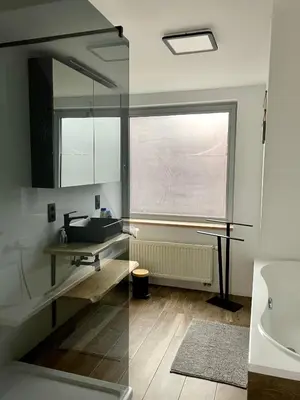 a bathroom with a sink and a window at Duplex appartement in rustige woonwijk in Mortsel