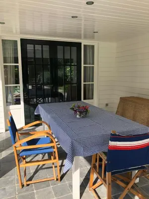 a table with two chairs and a blue and white table cloth at Schilde Cottage in Schilde