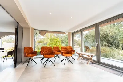 a room with orange chairs and a table and windows at Raesborre Homes - Self Check-in in Leuven