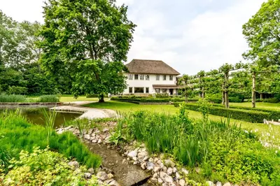 a garden with a house and a pond at Raesborre Homes - Self Check-in in Leuven
