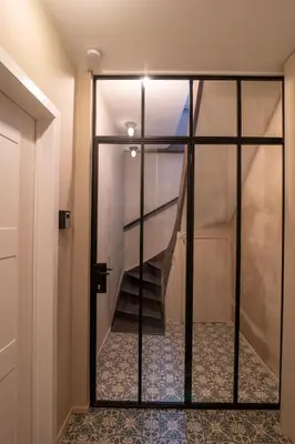 a staircase is seen through a glass door at Charming House in Le Sablon in Brussels