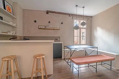 a kitchen with a bar with stools and a table at Lovely triplex in the heart of Le Sablon in Brussels