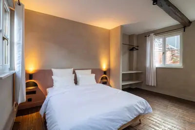a bedroom with a large white bed with two lamps at Lovely triplex in the heart of Le Sablon in Brussels