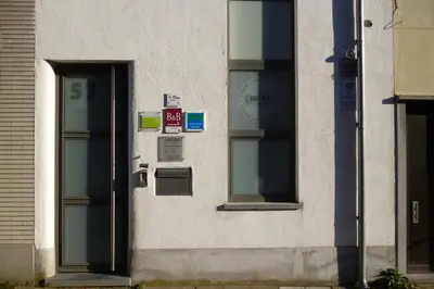 a building with two windows and a door at Su'ro Bed and Breakfast in Ghent