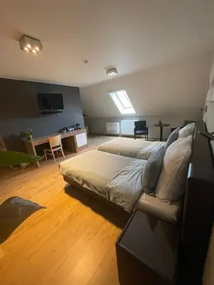 a bedroom with a bed and a living room at Bouwelhoeve 't Schuur in Grobbendonk
