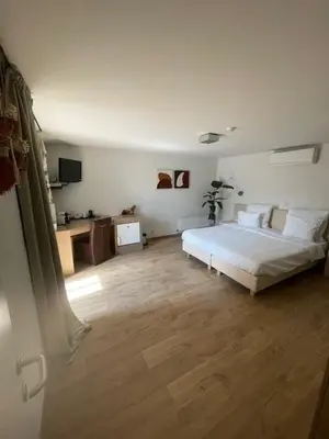 a bedroom with a white bed and a wooden floor at Bouwelhoeve 't Schuur in Grobbendonk