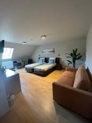 a bedroom with a bed and a couch in a room at Bouwelhoeve 't Schuur in Grobbendonk