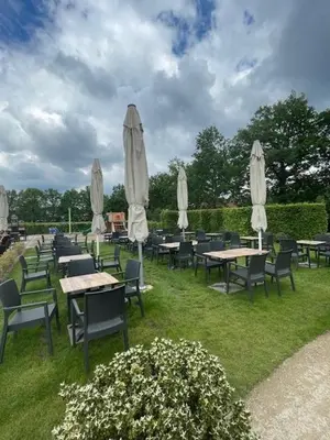 a group of tables and chairs with umbrellas at Bouwelhoeve 't Schuur in Grobbendonk