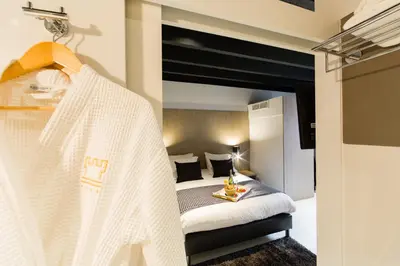 a hotel room with a bed with a white blanket at City Garden Ghent in Ghent
