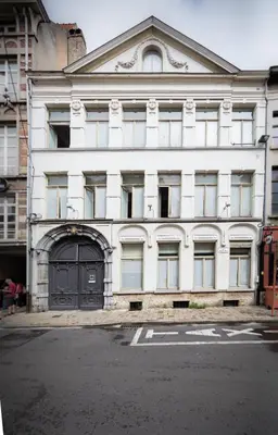 a white building with a black door on a street at City Garden Ghent in Ghent