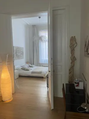 a room with a bedroom with a bed and a lamp at Apartment in trendy Chatelain center Brussels area Little Garden Internet wifi in Brussels