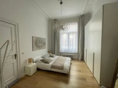 a white bedroom with a bed and a window at Apartment in trendy Chatelain center Brussels area Little Garden Internet wifi in Brussels