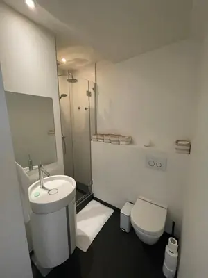 a white bathroom with a sink and a toilet at Apartment in trendy Chatelain center Brussels area Little Garden Internet wifi in Brussels
