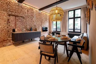 a dining room with a table and chairs and a brick wall at BTFL Living, Luxury Residences Antwerp, Zirkstraat in Antwerp