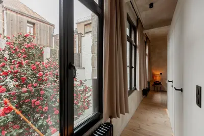a window with a view of a flower bush at BTFL Living, Luxury Residences Antwerp, Zirkstraat in Antwerp