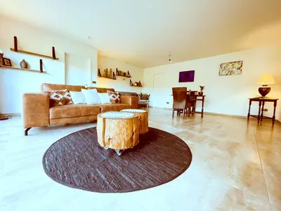 a living room with a couch and a tree stump in the middle at Vakantiehuis sINNE in Oostmalle