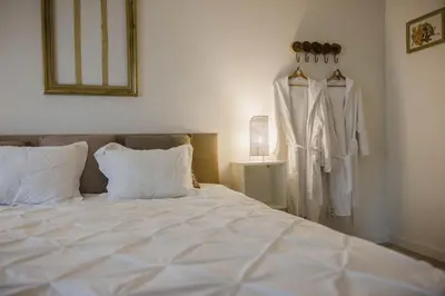 a bedroom with a bed and a robe hanging on a wall at Vakantiehuis sINNE in Oostmalle