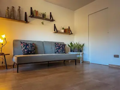 a living room with a blue couch and shelves at Vakantiehuis sINNE in Oostmalle