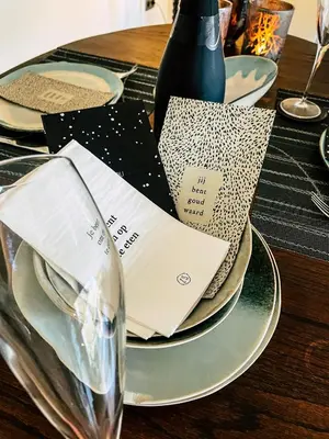a table with plates and a wine glass on it at Vakantiehuis sINNE in Oostmalle