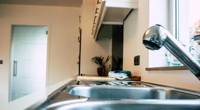 a kitchen with two sinks and a faucet at Vakantiehuis sINNE in Oostmalle