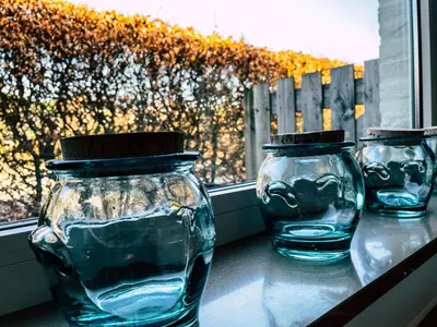 three glass vases sitting on a table in front of a window at Vakantiehuis sINNE in Oostmalle