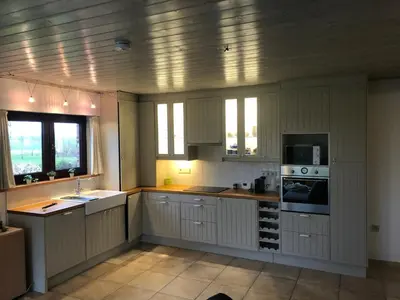 a kitchen with white cabinets and a stove top oven at De Reynaarthoeve in Assenede