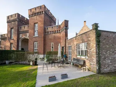 a large brick building with a patio in front of it at Apartment in Kruibeke Wissekerke Castle in Kruibeke