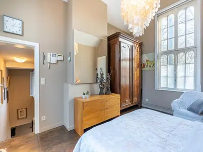 a bedroom with a large bed and a wooden dresser at Apartment in Kruibeke Wissekerke Castle in Kruibeke