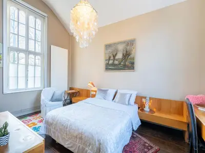 a bedroom with a bed and a chandelier at Apartment in Kruibeke Wissekerke Castle in Kruibeke