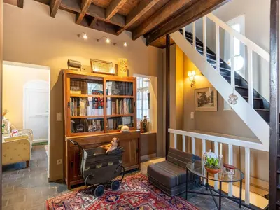 a living room with a staircase and a table at Apartment in Kruibeke Wissekerke Castle in Kruibeke